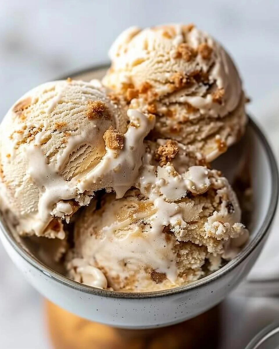 Creamy cookie butter ice cream served in a bowl with a drizzle of caramel