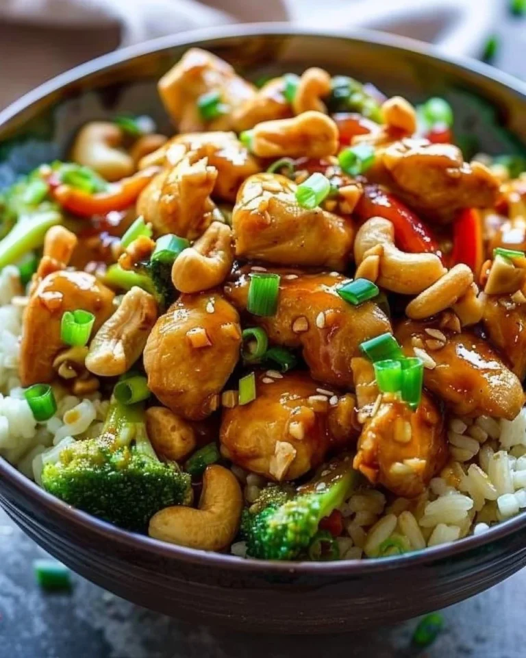 A vibrant dish of cashew chicken served with vegetables and rice on a dining table.