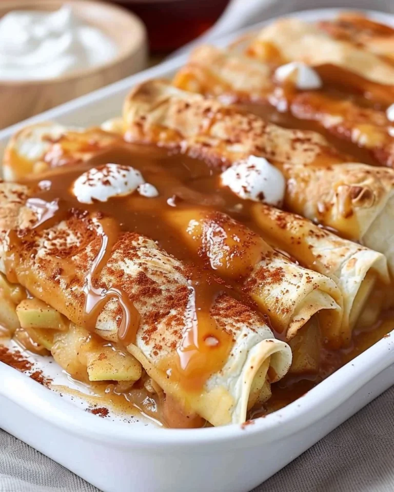 Delicious baked apple pie enchiladas drizzled with caramel sauce